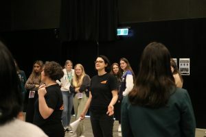 Two members of Lightbulb Improv leading young women through an interactive improv activity